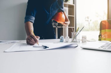 Mimar veya mühendis Resepsiyon ofis planı ile üzerinde kalem kullanarak kask ile elleri. Mühendislik araçları ve inşaat kavramı. Mimar ve iş kavramı.