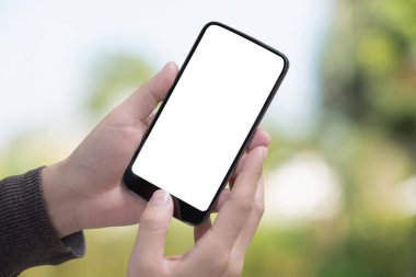 Erkek el Smartphone Park'ta tutarak. Boş ekran cep telefonu grafik görüntü montajı için