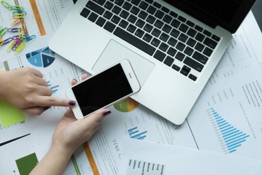Mali belge ve dizüstü bilgisayar işyeri ağındaki smartphone kullanarak iş kadını üstten görünüm