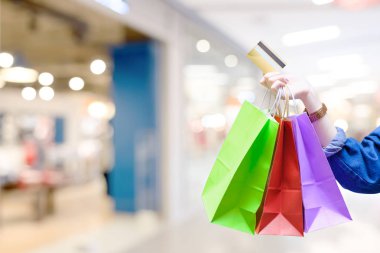 Alışveriş torbaları ile renkli kadınla ve Kumaş Dükkanı arka plan - alışveriş kredi kartı ödeme kavramı ile kredi kartı
