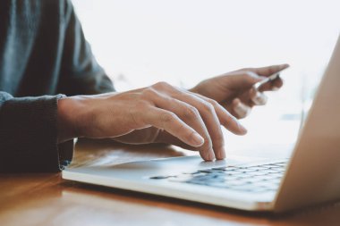 Çevrimiçi ödeme, akıllı telefon tutan adamın elleri ve online alışveriş için kredi kartı kullanmak..