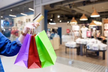 Alışveriş torbaları ile renkli kadınla ve Kumaş Dükkanı arka plan - alışveriş kredi kartı ödeme kavramı ile kredi kartı