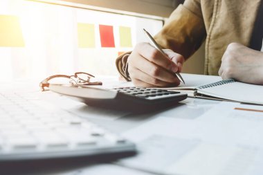 Kadın eli hesap makinesini kullanarak kapatın ve yazılı yapmak fiyat ya da finansal belgeden iş - iş finansal kavramı hakkında hesaplamak notla