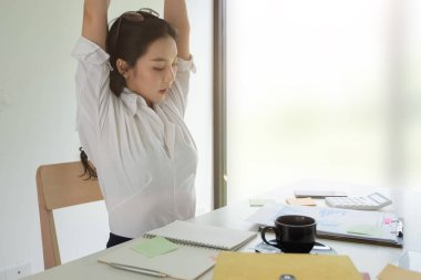 İş kadını ofisin arkasında rahat bir şekilde dinleniyor, işten sonra mutlu bir kadın ofiste dinleniyor.