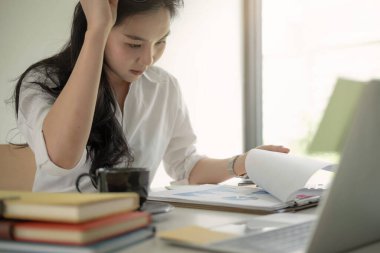 Genç Asyalı girişimci iş yerinde önemli kararlar verirken kafa yoruyor. Yoğunlaştırılmış ciddi ofis çalışanı. Milenyum kadını sonuçları analiz ediyor.