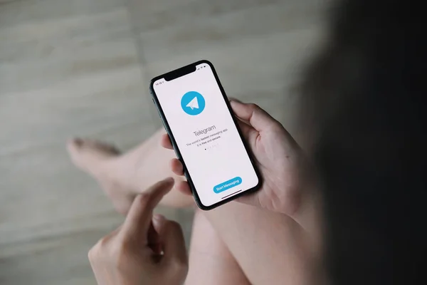 CHIANG MAI, THAILAND JUN 21 2020: Mão de mulher segurando iPhone X com serviço de rede social Telegrama na tela. iPhone 10 foi criado e desenvolvido pela Apple Inc — Fotografia de Stock