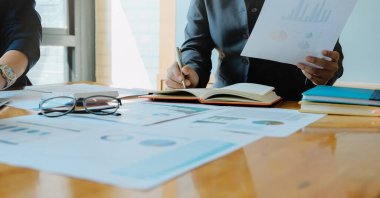 İş kadını toplantı odasında kalemle not defterine el yazısı yazmış.