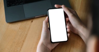 Umman iş yerinde akıllı telefonu tutuyor. Grafik görüntüleme için boş ekran cep telefonu..