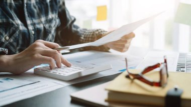 Finans, vergi, muhasebe, istatistik ve analitik araştırma konseptini hesaplamak için hesap makinesi ve dizüstü bilgisayar kullanan İşadamı kapat