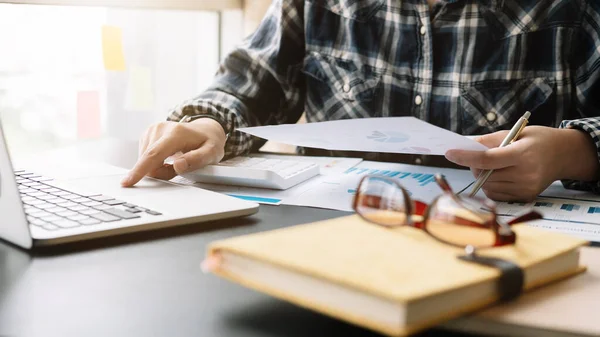 Close up Empresario que utiliza la calculadora y la computadora portátil para calcular las finanzas, impuestos, contabilidad, estadísticas y el concepto de investigación analítica — Foto de Stock