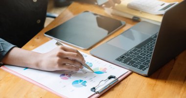 Ofisteki ilerlemeyi belirten finansal rakamları analiz eden bir iş danışmanı