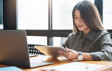 Genç kadın iş analizi için tablet bilgisayar kullanıyor