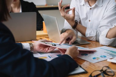 Bir grup Asyalı iş adamı pazarlama stratejisi için beyin fırtınası yapıyor