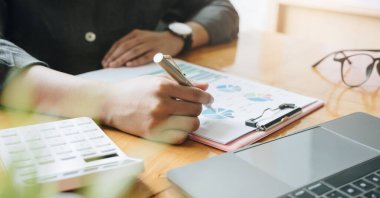 Masrafları ve muhasebe kavramını hesaplamak için ofiste hesap makinesiyle finans hakkında çalışan bir hesabı kapat