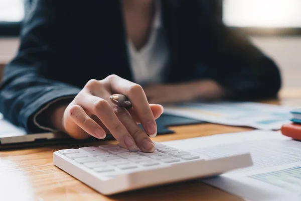 Contador que trabaja en escritorio usando la calculadora para calcular el informe financiero — Foto de Stock