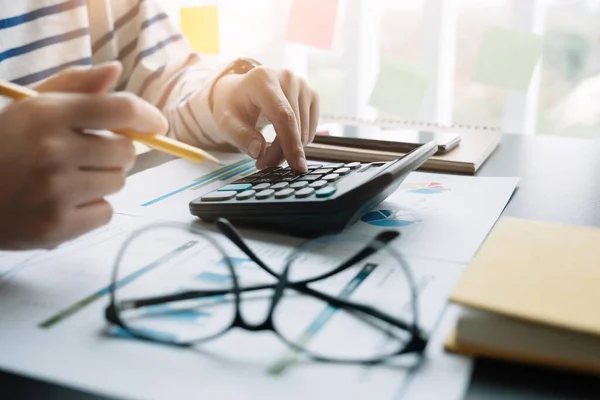 Проанализируйте финансовый бюджет с помощью калькулятора в офисе — стоковое фото