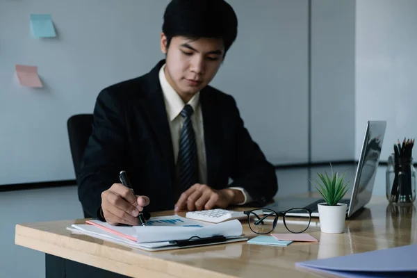 Hombre de negocios asiático que trabaja con ordenador portátil para las finanzas en la oficina —  Fotos de Stock