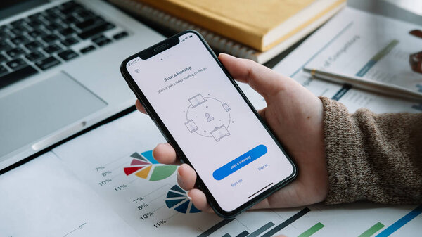 CHIANG MAI, THAILAND - APR 11, 2020 : A working from home employee is downloading the Zoom application social platform, ready for internet meetings, remote workers or online education