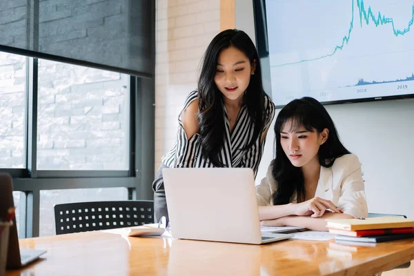 Deux jeunes femmes d'affaires asiatiques travaillant ensemble dans un bureau moderne — Photo