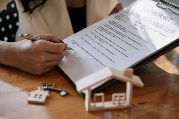 부동산 중개업자는 집을 매입하거나 판매하기 위한 고객 서명 계약서에 서명하도록 손을 제공 한다. 부동산 개념 접촉 협정 — 스톡 사진