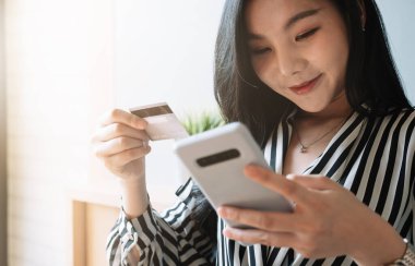 Çevrimiçi alışveriş e-ticaret çevrimiçi ödeme kavramı için akıllı telefon ve kredi kartı kullanan kadını kapat.