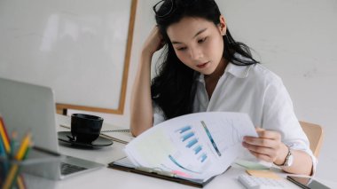 Finansal pazarlama raporuyla çalışan ciddi odaklı iş kadını