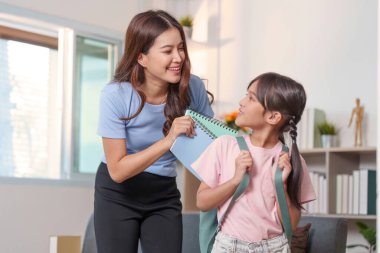 Bir anne ve kız okula hazırlanırken, öğrenme ve aile bağı kurma sevincini vurguluyor..