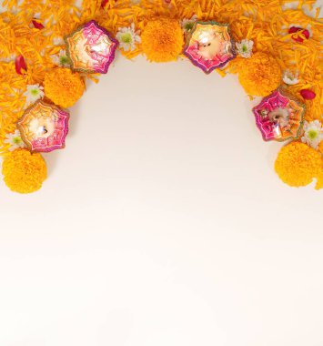 Renkli diyas ve kadife çiçeklerinin sanatsal düzenlemesi Diwali 'de neşe ve kutlamaları sembolize eden neşeli bir kemer oluşturuyor..