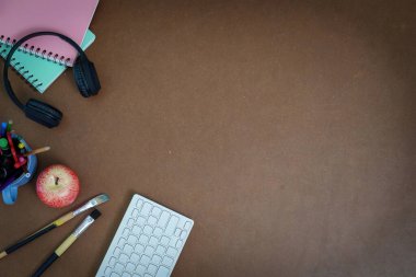 Elmalı, kulaklıklı ve klavyeli bir ofis sahnesi, yaratıcı bir ortamda uzaktan çalışmayı ve üretkenliği temsil ediyor..