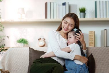 Bir anne ve kızı, huzurlu bir ortamda yakın ilişkileri ve duygusal desteklerini vurgulayarak, neşeli bir kucaklaşmayı paylaşıyorlar..