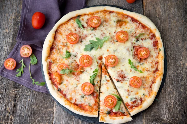 Pizza Margarita with tomatoes on wooden backgroun
