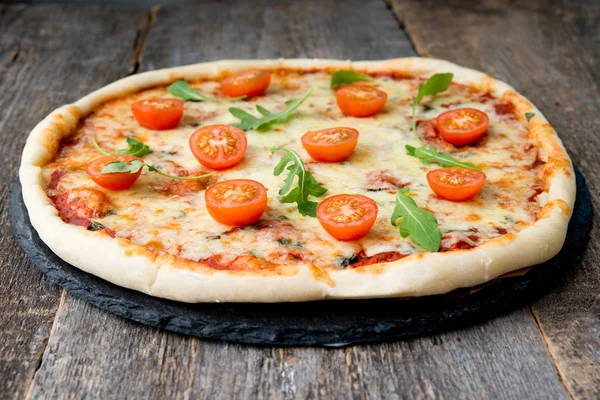 Pizza Margarita with tomatoes on wooden backgroun