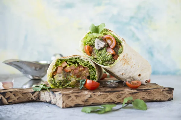 Burrito wraps with vegetables and sauce pesto.Roll with vegetables, mushrooms and pesto sauce. Vegetarian kebab. Of diet food.