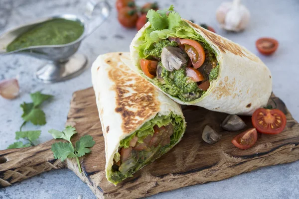 Burrito wraps with vegetables and sauce pesto.Roll with vegetables, mushrooms and pesto sauce. Vegetarian kebab. Of diet food.