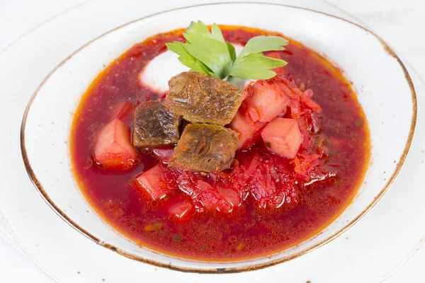 Traditional Ukrainian borscht with beef and sour cream isolated on white background
