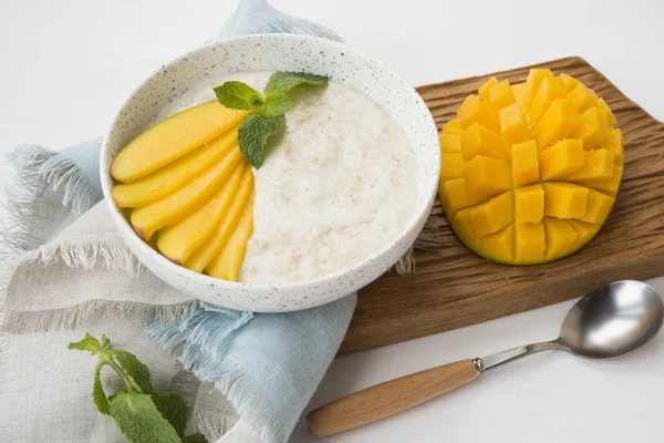 Oatmeal bowl with fresh mango. Healthy breakfast.
