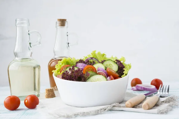 Summer vegetable salad with seasonal vegetables on rustic wooden background.