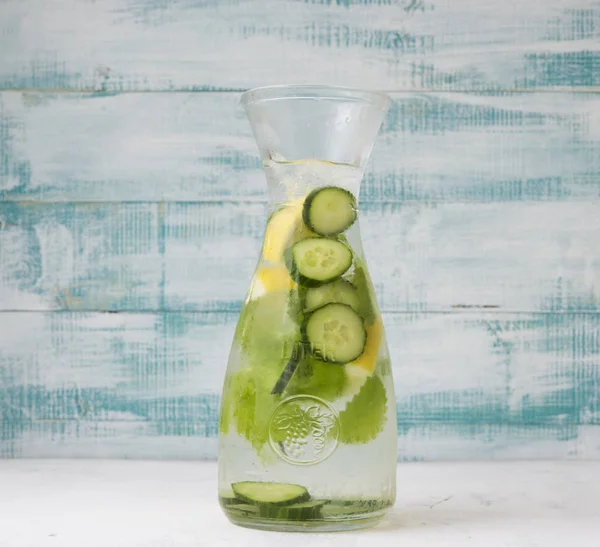 Pitcher of refreshing homemade lemonade with ice, cucumber and mint.