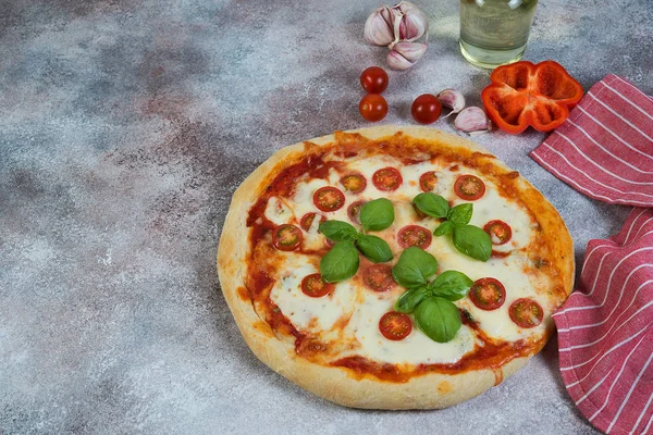 Pizza Margarita with tomatoes and mozzarella cheese on a concrete background. Horizontal photo with copy space