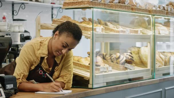 Lövés Egy Szép Boldog Afrikai Női Baker Jegyzeteket Mosolyog Kamerába — Stock videók