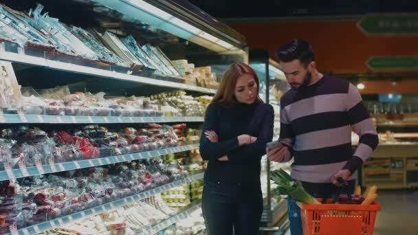 Szczęśliwa Para Piękny Zakupy Supermarkecie Razem Człowiek Sprawdzanie Listy Zakupów — Wideo stockowe