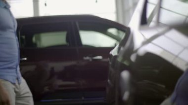 Genç adam yeni araba bakmak için geliyor. O araba vücut dokunarak arabayı nasıl boyanır arıyor.