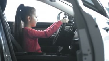 Küçük kız dingillerdir Tekerlek dönüyor. O yeni arabada oturma.