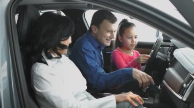 Aile yeni araba multimedya arıyor. Baba, karısıyla kızını yeni araba multimedya köknar gösterir. Onlar için yeni bir araba arıyoruz.