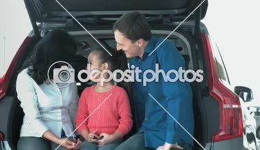 Aile söz, araba gövde üzerinde oturuyor. Güleryüzlü, olduklarını ve mutlu.