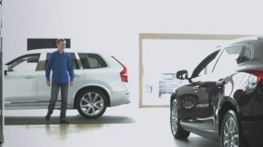 Erkekler için yeni bir araba arıyor. Araba Bayilik o. O kahverengi arabada oturmak.