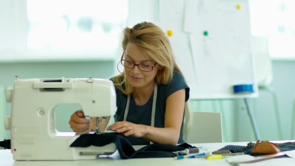 女孩缝制在缝纫机上的布 并微笑着 — 图库视频影像