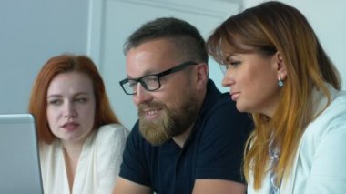 Ofiste iş arkadaşları. Orta yaşlı adam bir sakal ve gözlük ile taslak tartışırken office içinde belgili tanımlık laptop iki arkadaşları ile oturur