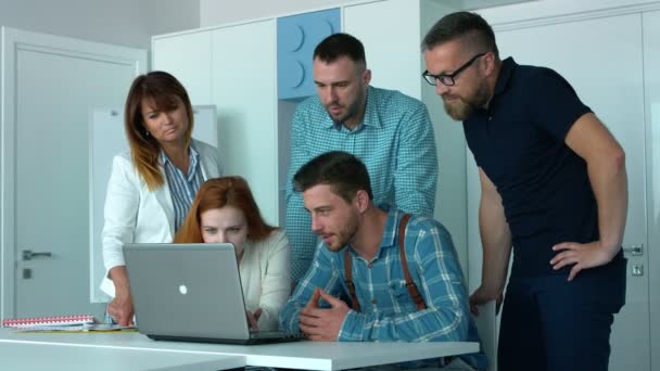 五名年轻员工正在办公室里看着笔记本电脑的计划 他们穿着商务休闲 — 图库视频影像