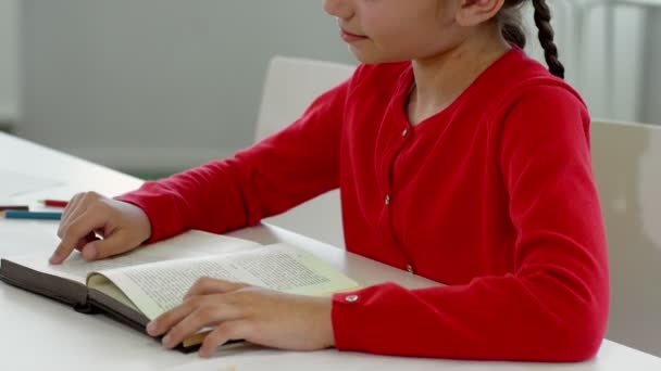 穿着红色夹克的小女孩在白色办公室看书 — 图库视频影像